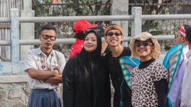 Kelebek kanatları ve leopar desenli üstler dahil renkli kostümler giymiş bir grup insan, Bandung - Endonezya, 17 Ağustos 2024