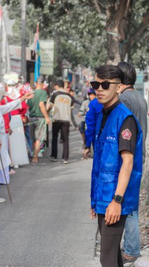 Bandung - Endonezya, 17 Ağustos 2024 'te bir topluluk etkinliği ya da geçit törenine katılan birkaç kişinin olduğu bir sokak sahnesi.