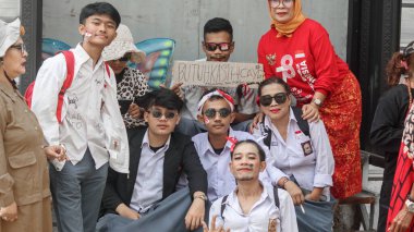 Bir grup Endonezyalı kadın ve erkek, Endonezya 'nın Bağımsızlık Günü' nü yüz çıkartmaları, el hareketleri ve vatansever ruh ile kutluyor. Bandung - Endonezya, 17 Ağustos 2024