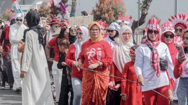 Endonezya 'nın Bağımsızlık Günü' nü kutlayan canlı bir geçit töreni. Geleneksel ve modern giysiler içinde milli gurur gösteren insanlar. Bandung - Endonezya, 17 Ağustos 2024
