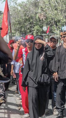 Endonezya 'nın Bağımsızlık Günü' nü kutlayan canlı bir sokak geçidi. Geleneksel ve modern kostümlerin içinde parlak güneşin altında yürüyen katılımcılarla birlikte. Bandung - Endonezya, 17 Ağustos 2024