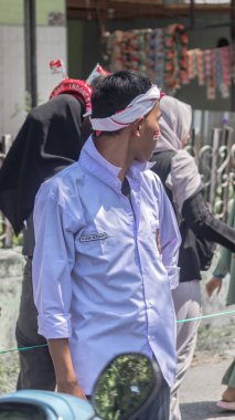 Bağımsızlık Günü kutlamalarında beyaz gömlek ve saç bandı takan Endonezyalı genç bir adam, Bandung - Endonezya, 17 Ağustos 2024