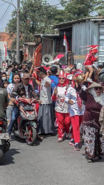 Kırmızı ve beyaz kıyafetler, bayraklar ve dekorasyonlarla dolu Endonezya 'nın Bağımsızlık Günü geçidi kalabalık bir sokakta neşeyle kutlanıyor. Bandung - Endonezya, 17 Ağustos 2024
