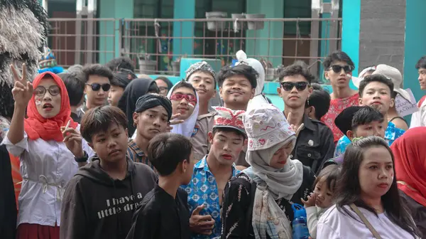 İnsanlar, 17 Ağustos 2024 'te geleneksel ve günlük kıyafetler olan Bandung-Endonezya' da barış işaretleri atıp kutlamaların tadını çıkarıyorlar.