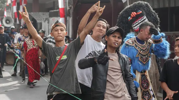 Geleneksel kostümler, eşsiz maskeler ve neşeli ifadelerle sanatçıların yer aldığı canlı bir kültürel geçit töreni. Kültür ve şenlik temaları için mükemmel, Bandung - Endonezya, 17 Ağustos 2024