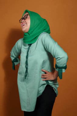 Kendine güvenen Müslüman kadın neşeli bir ifadeyle cesurca poz veriyor.