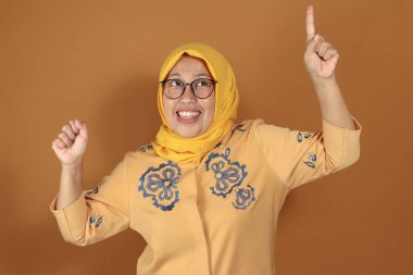 Mutlu Müslüman kadın heyecanlı bir ifade ve neşeli bir gülümsemeyle, kutlama, sevinç ve başarı konseptine uygun