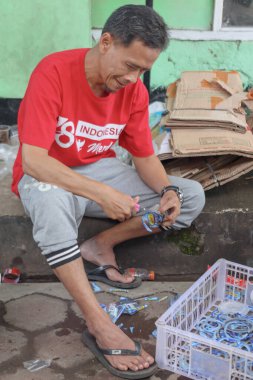 Bandung, Endonezya 29 Nisan 2025, Geri Dönüşüm Amaçlı Plastik Kesme Adam