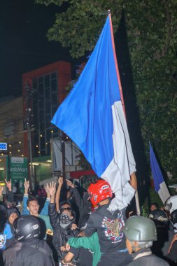 Bandung, Endonezya - 09 Mayıs 2025: Persib Bandung Liga 1 şampiyonası sokak kutlamalarında taraftarlar el ve bayrakları kaldırdı