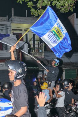 Bandung, Endonezya - 09 Mayıs 2025: Persib Bandung taraftarları Liga 1 şampiyonluğu ve enerjik sokak kutlamalarından sonra bayrağıyla geçit töreni yaptılar