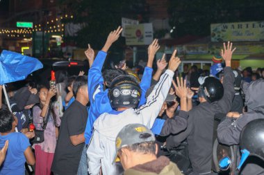 Bandung, Endonezya - 09 Mayıs 2025: Persib Bandung 'un sokak toplantısı sırasında Liga 1 ünvanını kazanmasını kutlamak için taraftarlar ellerini kaldırdı