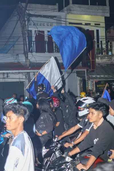 Bandung, Endonezya - 09 Mayıs 2025: Persib Bandung taraftarları Liga 1 şampiyonluğunu kutlamak için sokak konvoyunda bayrak sallıyor
