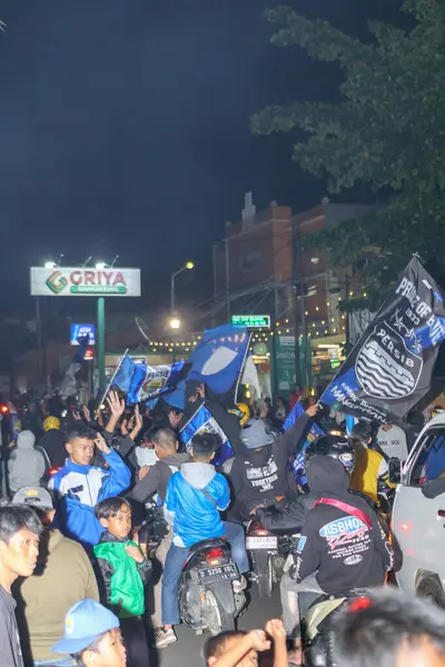 Bandung, Endonezya Mayıs 09 2025: Persib Bandung taraftarları Liga 1 şampiyonluğunu kutlayan motosikletlerle geçit töreni yapıyorlar, sokak mitinginde takım bayraklarını sallayarak spor tutkusu ve toplum gururunu gösteriyorlar