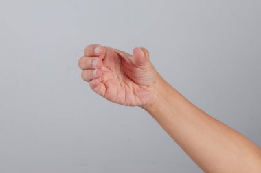 Kıvrımlı insan eli, içe ve başparmağına doğru bükülmüş el hareketi kavramaya ya da almaya hazır olduğunu, tarafsız bir arkaplanda yakalandığını gösteriyor.