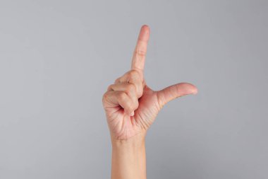 L şeklindeki parmak işaretini gösteren el hareketi, sembolik kullanım için mükemmel, minimum UI, eğitim veya iletişim kavramlarında ifade