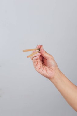 El, dekore edilmiş bambu çubuklarını arka planda tutmanın doğru yolunu gösteriyor.