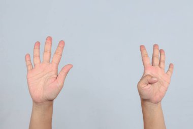 Dokuz numarayı oluşturan iki el, bir elde beş parmak, diğer elde baş parmak hareketi ile parmak saymayı ya da sayısal ifadeyi temsil eden gri arkaplanı temsil eder.