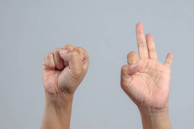 Öndeki iki el bir yumruk gösteriyor ve üç parmağını yan yana kaldırdı.