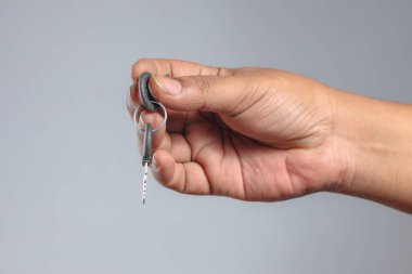 İnsan elini kapat metal anahtarı plastik anahtarlıkla sık.