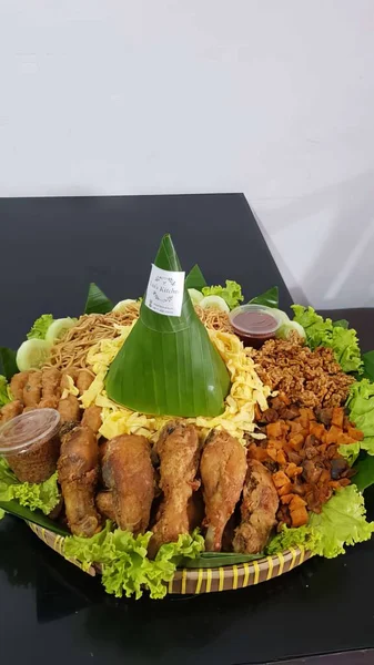 Tepesinde yaprak olan bir tabak yemek.