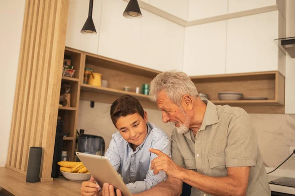 Happy Grandfather Talking Grandson While Using Tablet Computer Kitchen Home — Stock Photo, Image