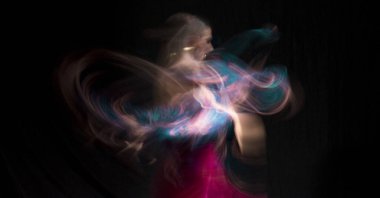 Renkli elbiseli ve uzun pozlu flamenko dansı yapan bir kadın. Medellin, Kolombiya. 