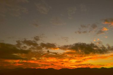 Şehirde turuncu bulutlar ve güzel renkli günbatımı olan bir arka plan. Medellin, Antioquia.