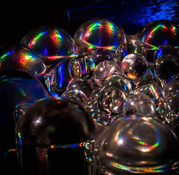 Holografik kağıtta güneş ışığı olan küçük cam toplar. Medellin, Antioquia, Kolombiya. 