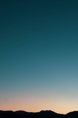 Medellin şehrinde bulutsuz ve rengarenk bir gün batımı. Kolombiya