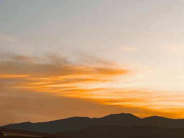 Turuncu gökyüzü ile güzel bir gün batımı ve Manrique mahallesinden büyük bir bulut görünüyor. Medellin, Antioquia, Kolombiya.