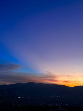 Mavi ve turuncu gökyüzü ile renkli gün batımı. Medellin şehrinin manzarası.