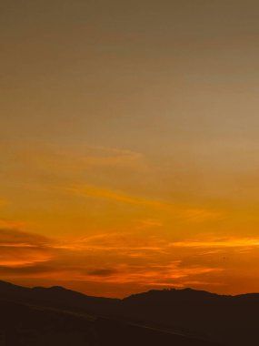 Turuncu gökyüzü ile güzel bir gün batımı ve Manrique mahallesinden büyük bir bulut görünüyor. Medellin, Antioquia, Kolombiya.