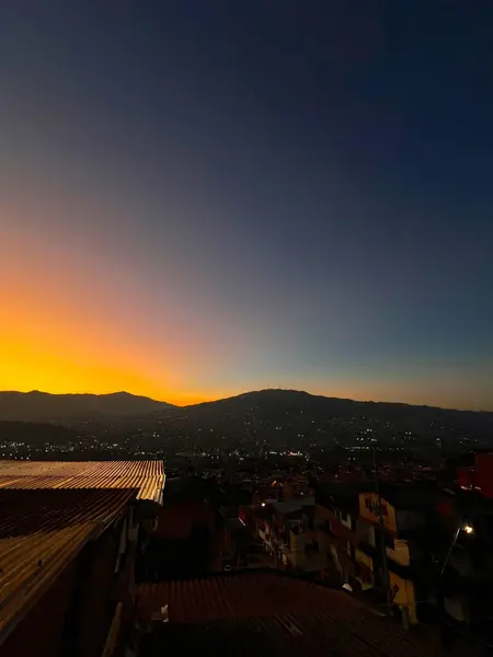 Mavi ve turuncu gökyüzü ile renkli gün batımı. Medellin şehrinin manzarası.