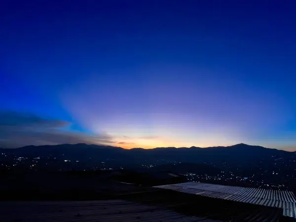 Mavi ve turuncu gökyüzü ile renkli gün batımı. Medellin şehrinin manzarası.