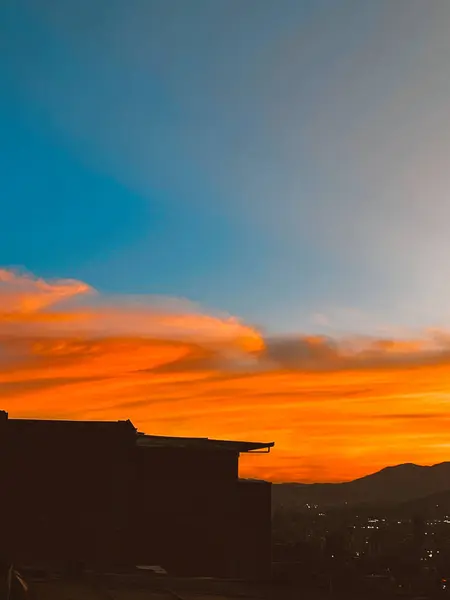 Turuncu gökyüzü ile güzel bir gün batımı ve Manrique mahallesinden büyük bir bulut görünüyor. Medellin, Antioquia, Kolombiya.