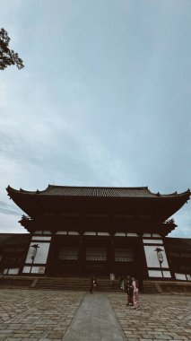 Nara, Japon. 25 Mart 2024: Daibutsu Budist Tapınağı ve gökyüzü bulutlu cephesi.