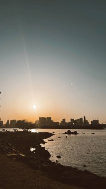 Odaiba, Tokyo Japonya 'da günbatımı ve binaların silueti ile şehir manzarası.