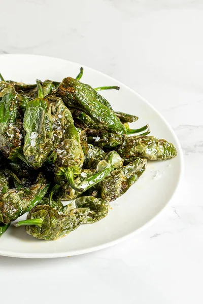 Several padron peppers grilled and seasoned with sea salt. High quality photo
