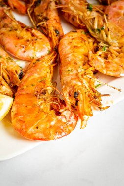 Close up of a plate of grilled prawns on a marble table. High quality photo