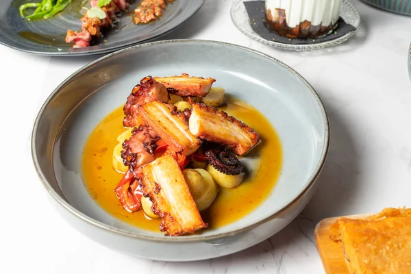 Delicious plate of octopus in sauce with potatoes. High quality photo