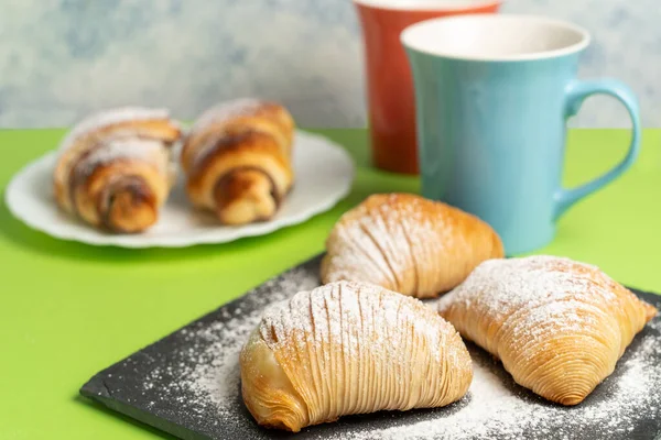 Avrupa mutfağının lezzetli tatları: Sfogliatella ve renkli arka planda bir fincan kahve ile çikolatalı kruvasan. Yüksek kalite fotoğraf