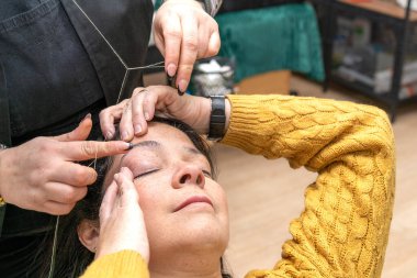 Kaş ağdası yaparken kaş makyajcısına yardım eden müşteriyi kapat. Yüksek kalite fotoğraf