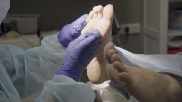 Podologe Entfernt Trockene Haut Von Der Fußsohle Eines Patienten Der — Stockvideo