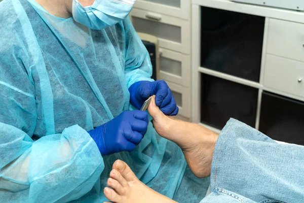 Medical pedicure: The podiatrist works carefully on her patients nails. Concept of hygiene and good foot care. High quality photo