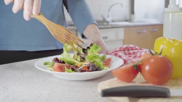 一个女人的手拿起沙拉 用木钳和几个蔬菜放在木板上 高质量的照片 — 图库视频影像