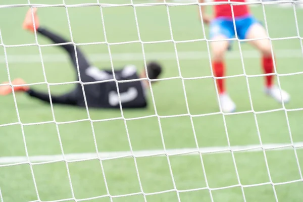 stock image Soccer goal net in focus while the goalkeeper and a player are out of focus. 