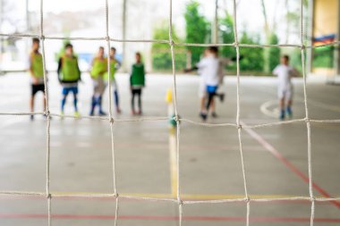 Bir grup çocuk topu boş kaleye atmak için futsal alıştırması yapıyor. Seçici odaklanma. Yüksek kalite fotoğraf