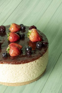 Çilekli kek ve yeşil tonlu bir ahşap. Kremalı pasta ve çilekli kremadan yapılan ev yapımı çilekli pasta. Yüksek kalite fotoğraf