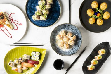 Suşi dahil çeşitli geleneksel Japon yemeklerini gösteren bir masa. Japon mutfağının otantik tatları. Yüksek kalite fotoğraf