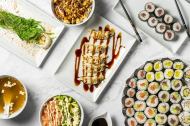 Suşi dahil çeşitli geleneksel Japon yemeklerini gösteren bir masa. Japon mutfağının otantik tatları. Yüksek kalite fotoğraf